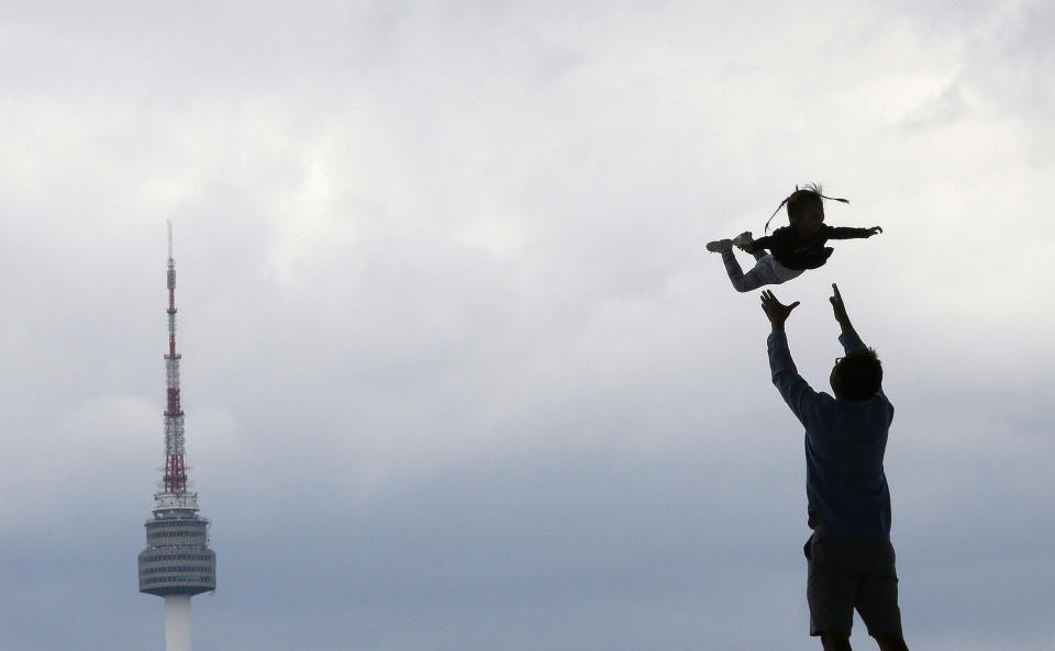 <p>A man throws her daughter in the air while they are silhouetted at the National Museum of Korea in Seoul, South Korea, Tuesday, Aug. 30, 2016. (AP Photo/Ahn Young-joon) </p>