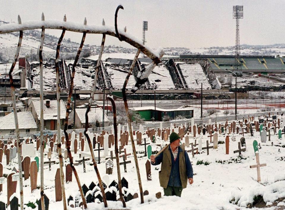 A gravedigger is photographed on March 31, 1997 passing through the snowy war cemetery next to the Kosevo Stadium A soccer field, also part of the complex, was turned during the siege of Sarajevo into a graveyard because of lack of other places where victims of the war could have been buried before it came to an end on Feb. 29, 1996.