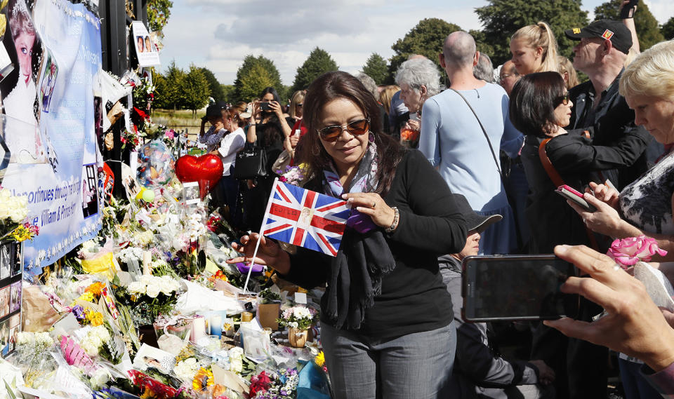<p>A woman poses for a photograph as people crowd around the gates of Kensington Palace in London to pay tribute to the late Diana, Princess of Wales, Thursday, Aug. 31, 2017. Tributes at the gates are to mark the 20th anniversary of Diana’s death, in a car crash in Paris on Aug. 31, 1997. (Photo: Kirsty Wigglesworth/AP) </p>