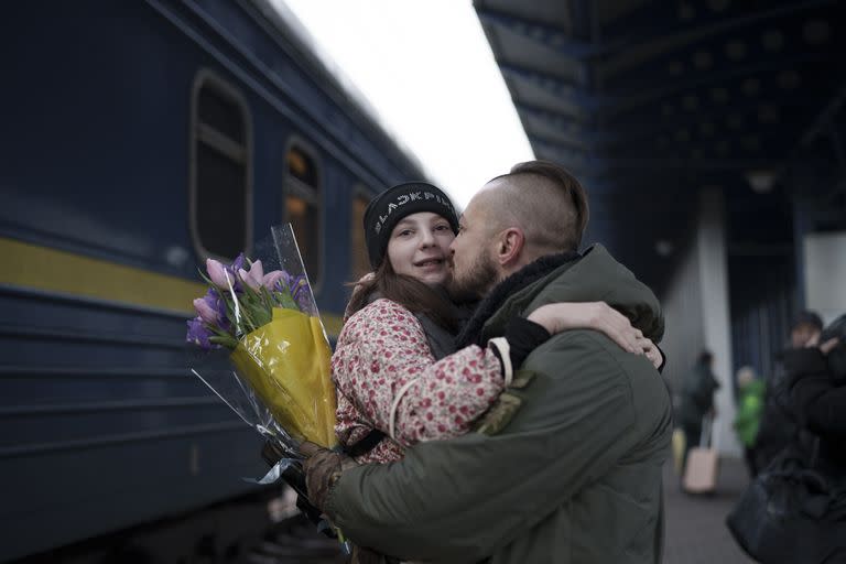 El soldado ucraniano Vasyl Khomko, de 42 años, abraza a su hija Yana tras su llegada a la estación ferroviaria, el sábado 31 de diciembre de 2022, en Kiev, Ucrania. (AP Foto/Roman Hrytsyna)