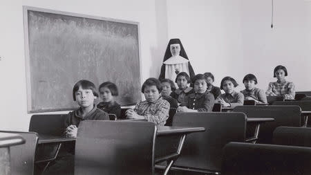 A group of female students and a nun pose in a classroom at Cross Lake Indian Residential School in Cross Lake, Manitoba in a February 1940 archive photo. REUTERS/Canada. Dept. Indian and Northern Affairs/Library and Archives Canada/e011080274/handout