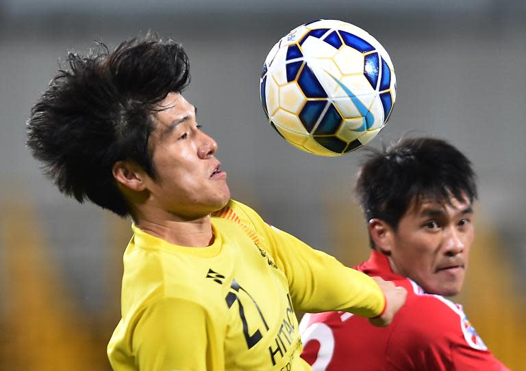 Japan's Kashiwa Reysol defender Kim Chang Soo (L) and Vietnam's Binh Duong forward Le Cong Vinh fight for the ball during their AFC Champions League Group Stage football match in Kashiwa on March 3, 2015