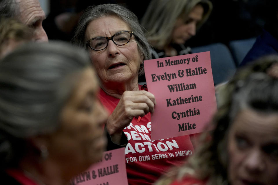 Kirsten Damphier holds a sign with the names of the six victims of the Covenant School shooting in March of 2023 during a meeting of the House Criminal Justice Subcommittee, Tuesday, March 26, 2024, in Nashville, Tenn. (AP Photo/George Walker IV)