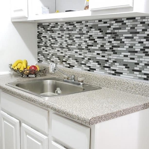 Gray, black and white backsplash shown above a kitchen cabinet