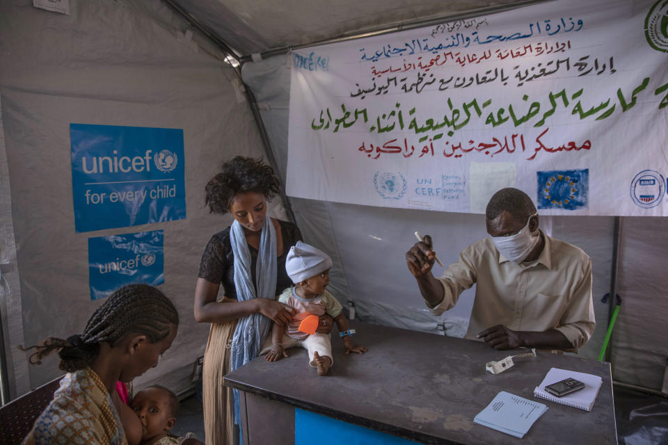 Tigray women who fled the conflict in Ethiopia's Tigray region, take shelter inside a UNICEF tent, as Filippo Grandi, U.N. High Commissioner for Refugees, visits Umm Rakouba refugee camp in Qadarif, eastern Sudan, Saturday, Nov. 28, 2020. (AP Photo/Nariman El-Mofty)