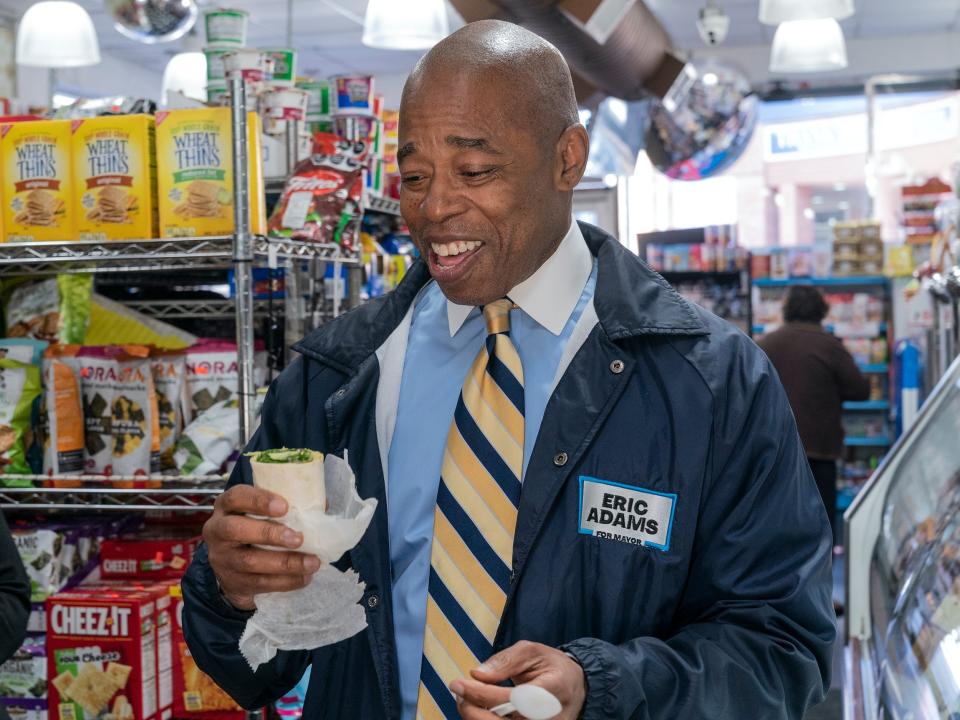 Eric Adams looks down at vegan wrap inside a New York City bodega.