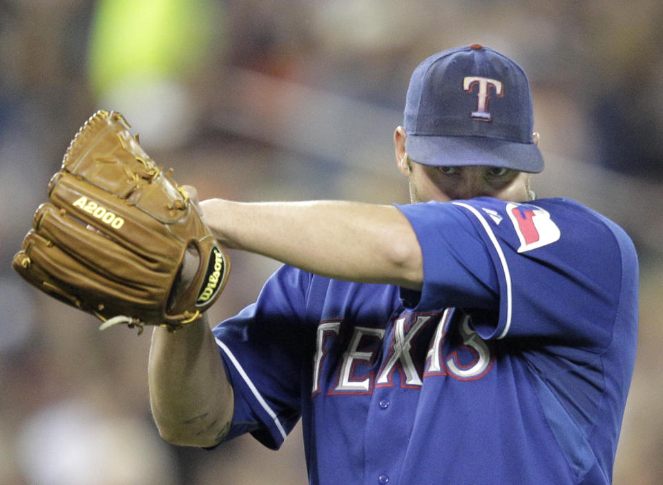 Texas Rangers starting pitcher Colby Lewis wipes his face during the sixth inning of Game 3 of baseball's American League championship series against the Detroit Tigers, Tuesday, Oct. 11, 2011, in Detroit. (AP Photo/Charlie Riedel)