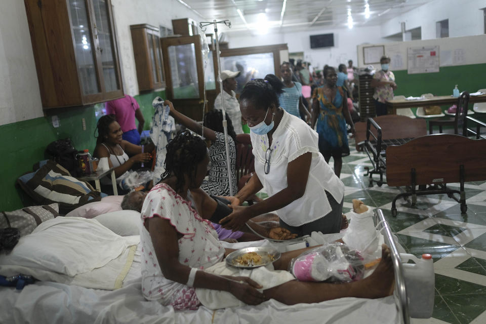 Nurse Gabrielle Lagrenade treats a patient at the Immaculate Conception Hospital, also known as the General Hospital of Les Cayes, Haiti, Sunday, Aug. 22, 2021, a week after a 7.2 magnitude earthquake. Lagrenade and her 21-year-old daughter Bethsabelle have been sleeping outside since Aug. 14, and describes her current living conditions simply as “inappropriate,” but she continues arriving for her daily shift at the hospital. (AP Photo/Matias Delacroix)