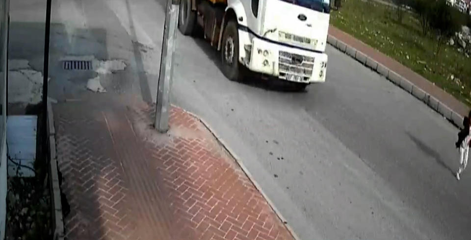 Mahra Melin Pinar, 9, running away from the dogs as the truck approaches her. 