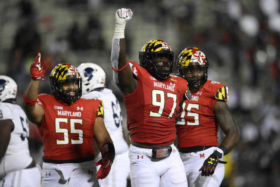 Maryland defensive lineman Sam Okuayinonu (97) reacts after he made a tackle during the first half of an NCAA college football game against Howard, Saturday, Sept. 11, 2021, in College Park, Md. Maryland defensive linemen Ami Finau (55) and Lawtez Rogers, right, look on. (AP Photo/Nick Wass)