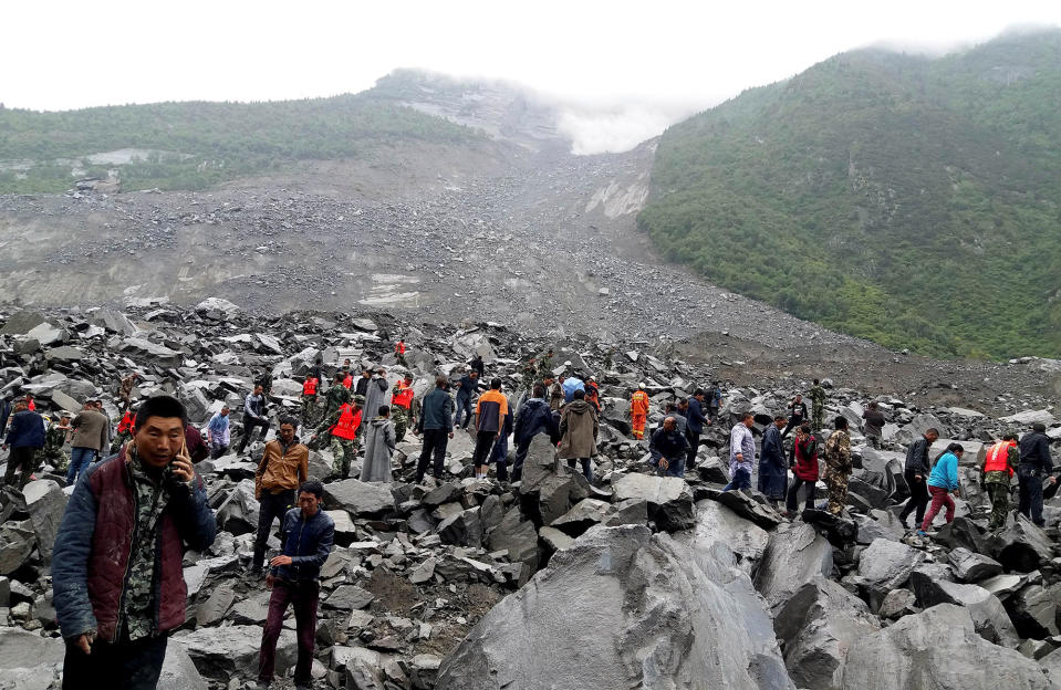 <p>People search for survivors at the site of a landslide that destroyed some 40 households, where more than 100 people are feared to be buried, local media reports, in Xinmo Village, Sichuan Province, China, June 24, 2017. (Photo: Stringer/Reuters) </p>