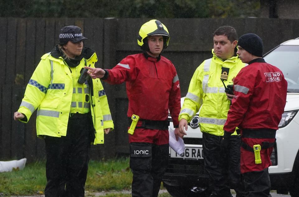 Emergency services go door to door speaking with residents and assist with putting out sandbags in Canal Road in Inverurie, Aberdeenshire (PA)