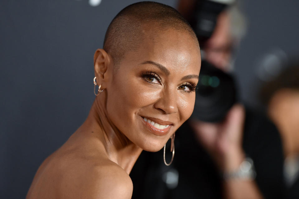 Jada Pinkett Smith looking back, tilting her head and smiling.