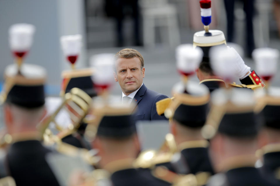 France's President Emmanuel Macron reviews troops before the start of the Bastille Day military parade, Tuesday, July 14, 2020 in Paris. France are honoring nurses, ambulance drivers, supermarket cashiers and others on its biggest national holiday Tuesday. Bastille Day's usual grandiose military parade in Paris is being redesigned this year to celebrate heroes of the coronavirus pandemic. (AP Photo/Christophe Ena, Pool)