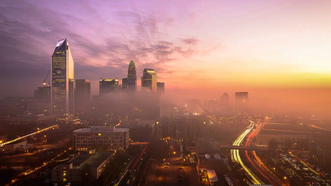 A foggy and colorful sunrise in Charlotte, North Carolina during the morning rush hour traffic.
