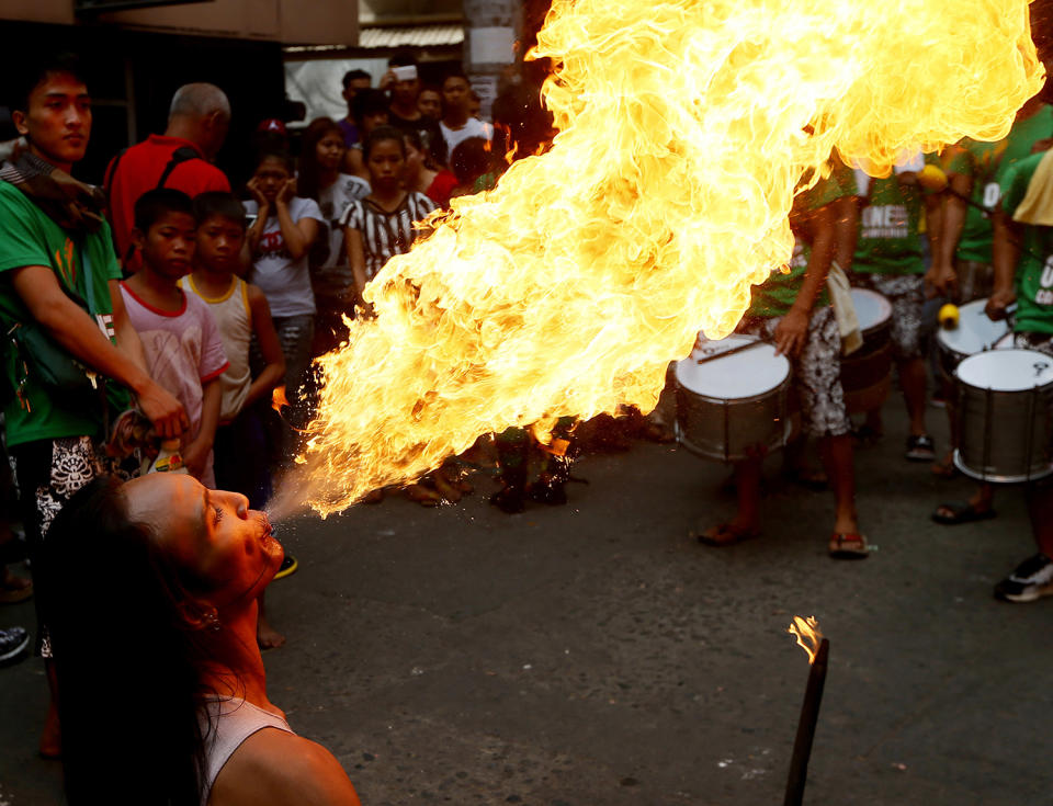 A fire-eater performs on the street during Chinese New Year celebrations, Saturday, Jan. 28, 2017, in the Chinatown area of Manila, Philippines. Chinese around the world are celebrating this year's Year of the Rooster according to the Chinese zodiac calendar. (AP Photo/Bullit Marquez)