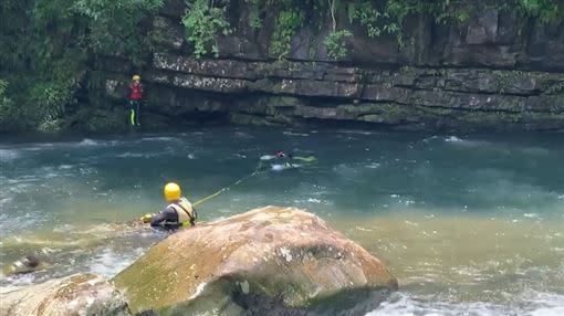 潛搜人員在落水點下方約300公尺處，溪中石頭下方找到落水失蹤的胡姓男子。（圖／翻攝畫面）