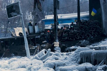 Anti-government protesters stand on fortifications erected against possible assaults by riot police in Kiev, January 28, 2014. REUTERS/Thomas Peter