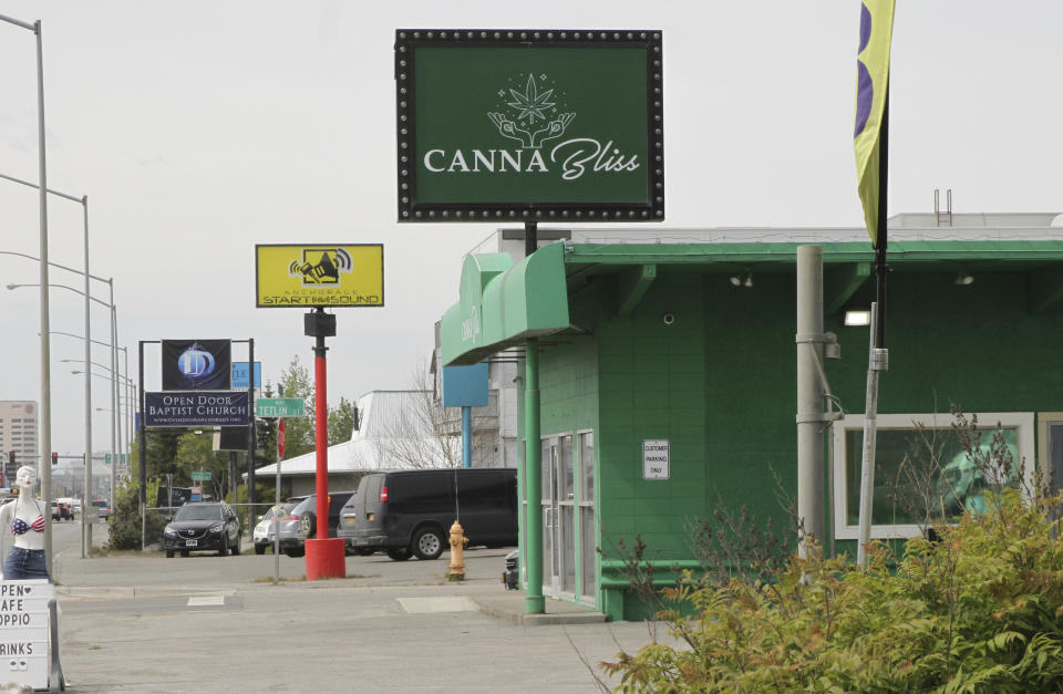 This May 27, 2021, shows a marijuana retail store down the block from the Open Door Baptist Church , located inside a former strip club in Anchorage, Alaska. Pastor Kenny Menendez hopes that the church — which is also situated between a sex store and downtrodden motels — could be a start to improving the neighborhood. (AP Photo/Mark Thiessen)