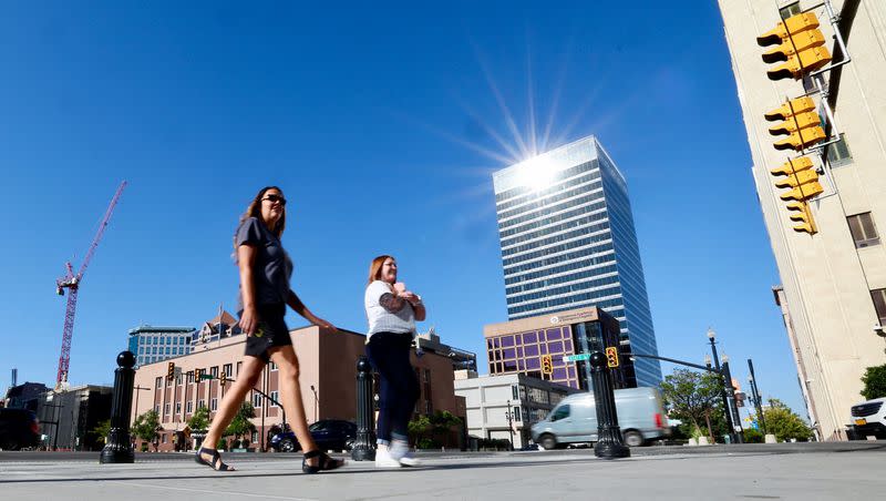 The sun reflects off the 111 Main building as two women walk on the sidewalk along State Street in Salt Lake City on Sept. 6, 2022. Above-normal heat is expected across Utah again between June and August this year.