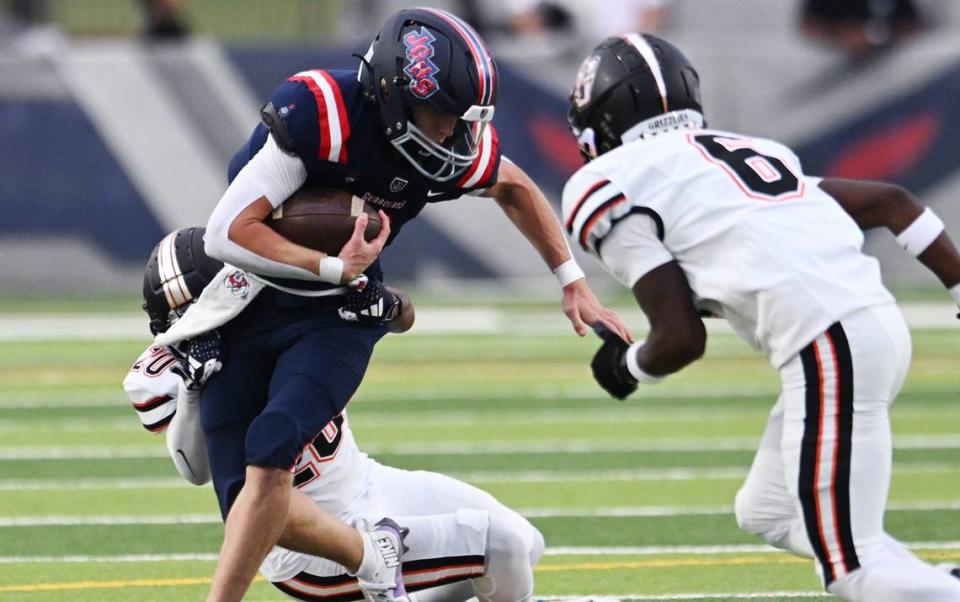 Central High’s Lonzo Jenkins, left background, pulls down Garza High quarterback Caleb Matthews, center, in the opening game of the 2024 season at Koligian Stadium Friday, Aug. 23, 2024 in Fresno.