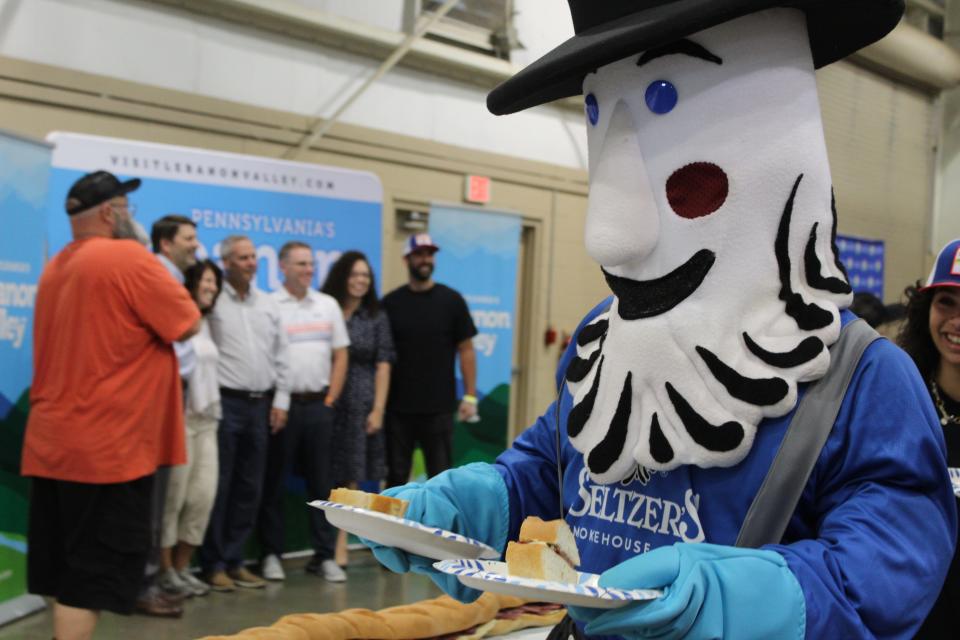 Seltzer's Smokehouse Meats mascot handing out slices of the 150 Lebanon Bologna Sandwich.