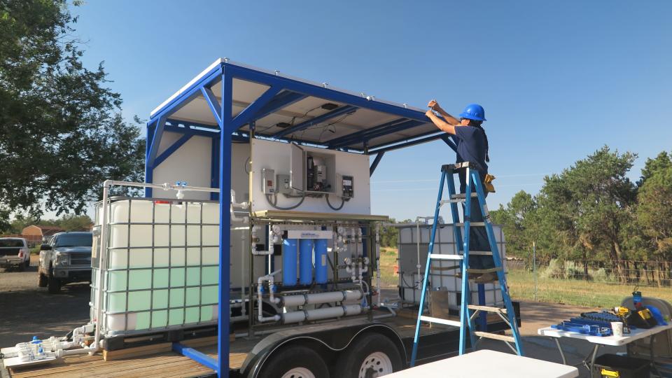 A Diné College employee makes the last tweaks on a solar-powered nanofiltration system. The mobile unit can treat about 1,500 gallons of water a day, removes contaminants like arsenic, fluoride and uranium from water.
