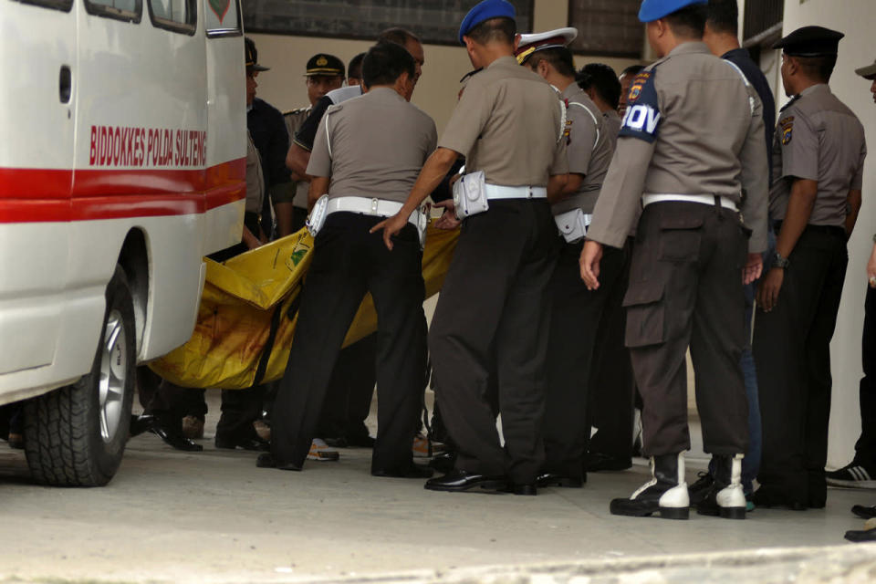 Police carry body bags of wanted militant in Palu
