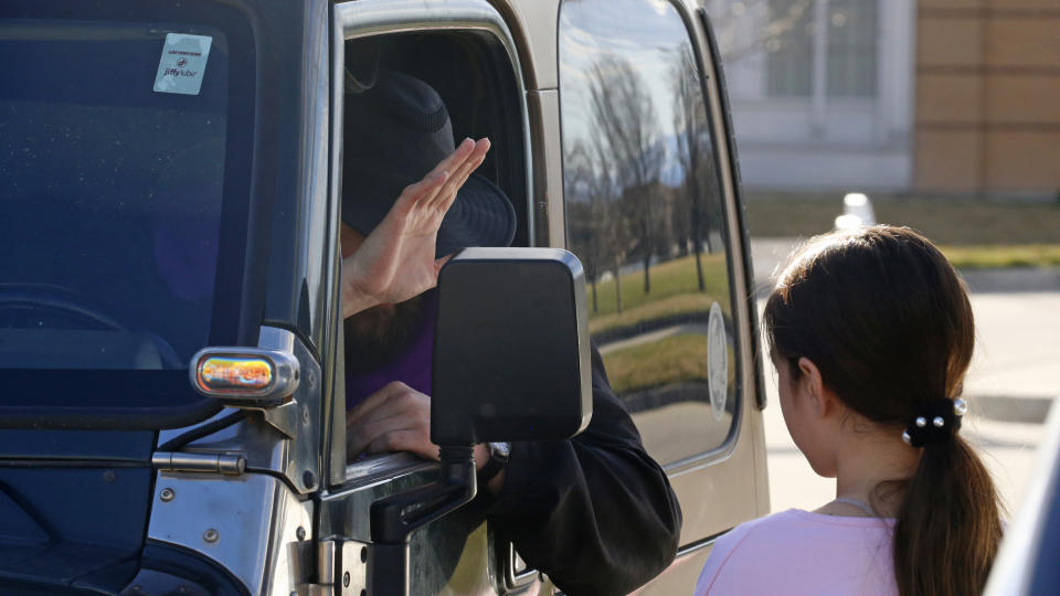 FILE - In this Sunday, March 22, 2020 file photo, Father Stephen Tilley sits behind his steering wheel as he listens to a 10-year-old girl during a "Meet Me at the Jeep" drive-up confession at Skaggs Catholic Center in Draper, Utah. With the threat of the new coronavirus closing churches, some Catholic priests in Utah offered to hear confessions from their vehicles. (AP Photo/Rick Bowmer)