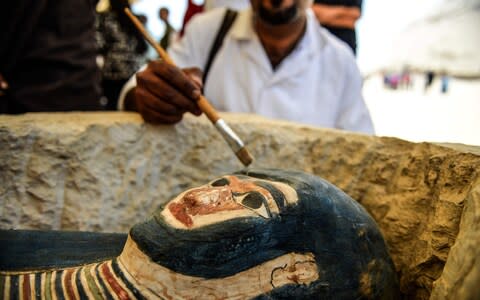 As part of the pyramid's re-opening, the authorities also showed off a new collection of stone, clay and wooden sarcophagi, some containing well-preserved mummies, plus wooden funerary masks and instruments - Credit: Mohamed El-Shahed/AFP