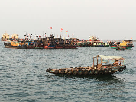 Fishing boats with Chinese national flags are seen at a harbour in Baimajing, Hainan province, April 7, 2016. REUTERS/Megha Rajagopalan