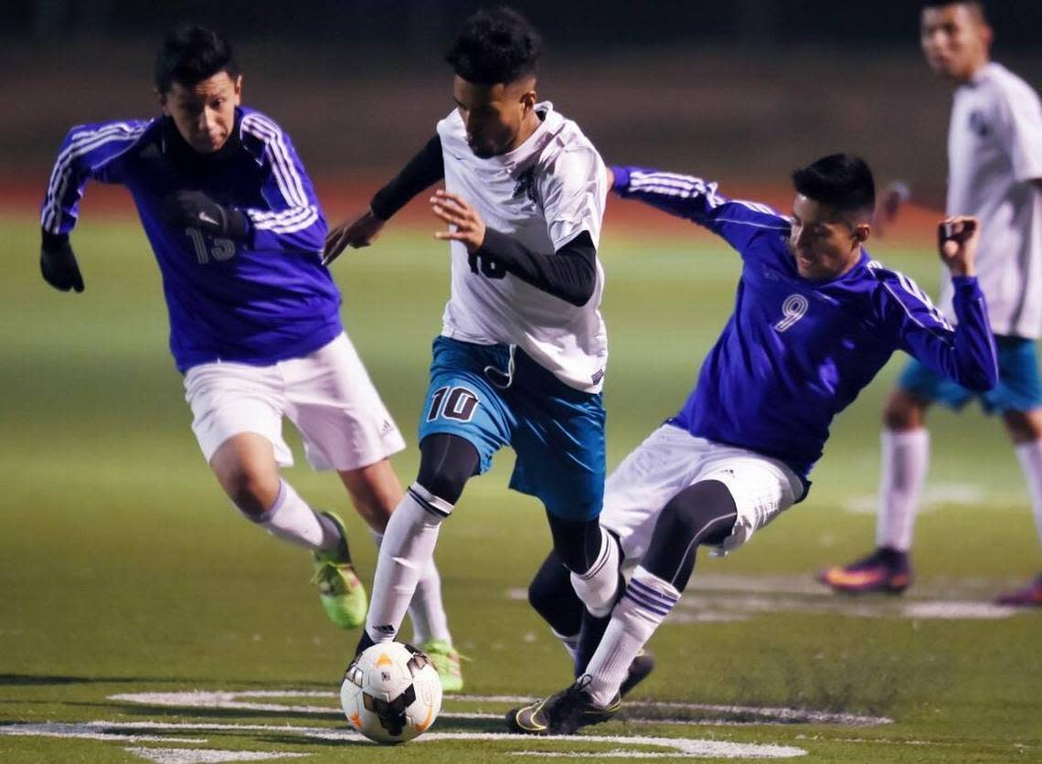 Mendota’s Danny Trejo, center, charges between Avenal’s Francisco Rosario, left, and Gerardo Calata, right, in a matchup Tuesday, Jan. 17, 2017 in Mendota, Calif. Mendota is the top seed for the CIF Southern California Regional Division V playoffs and will host No. 8 La Cañada in an opening-round match Tuesday, March 7, 2017. ERIC PAUL ZAMORA/ezamora@fresnobee.com