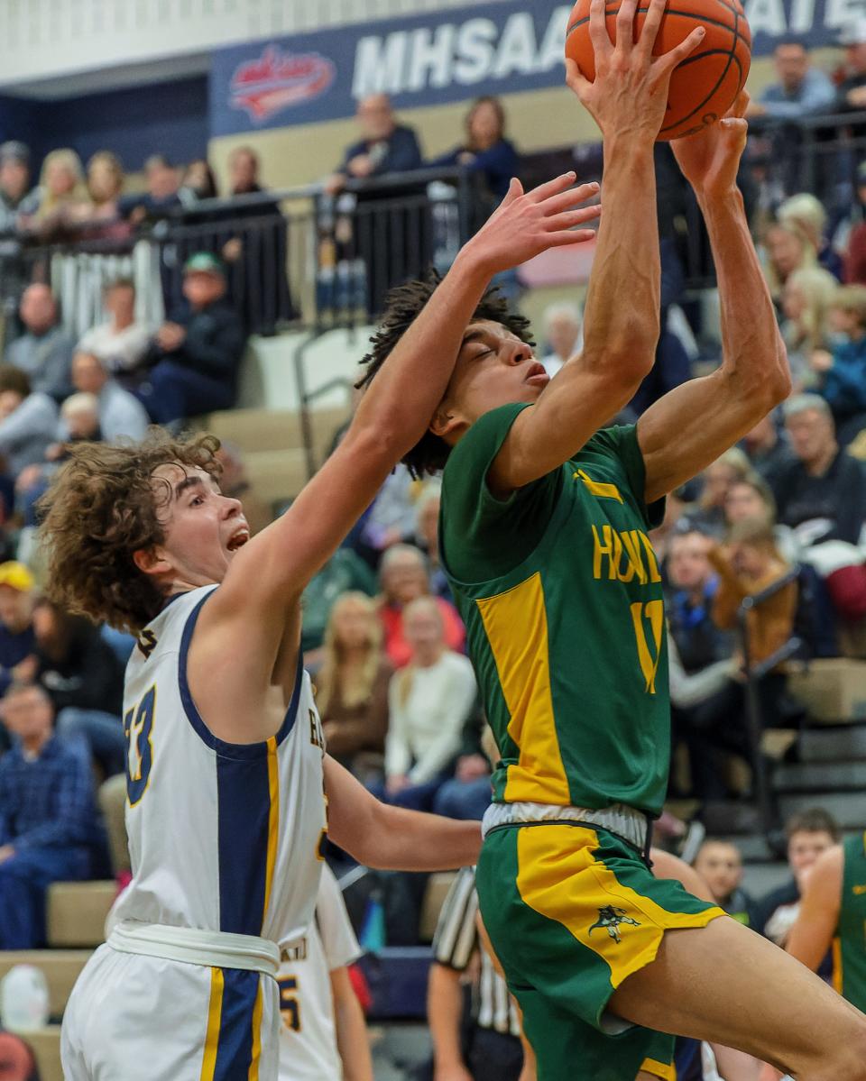 Howell's Jaylen Hicks takes the ball to the hoop while defended by Hartland's Alex Fernandez during the Highlanders' 55-27 victory Friday, Jan. 27, 2023.