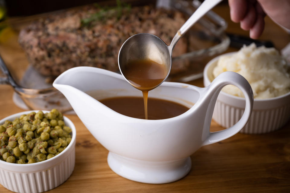 A saucer of gravy with peas and potatoes