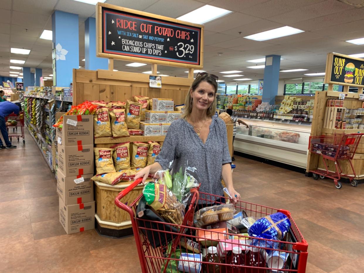 The writer standing with a cart full of food at Trader Joe's