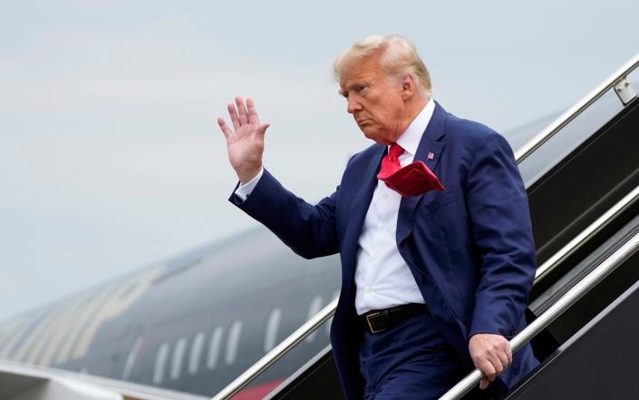 Donald Trump waves as he steps off his plane at Ronald Reagan Washington National Airport on Thursday