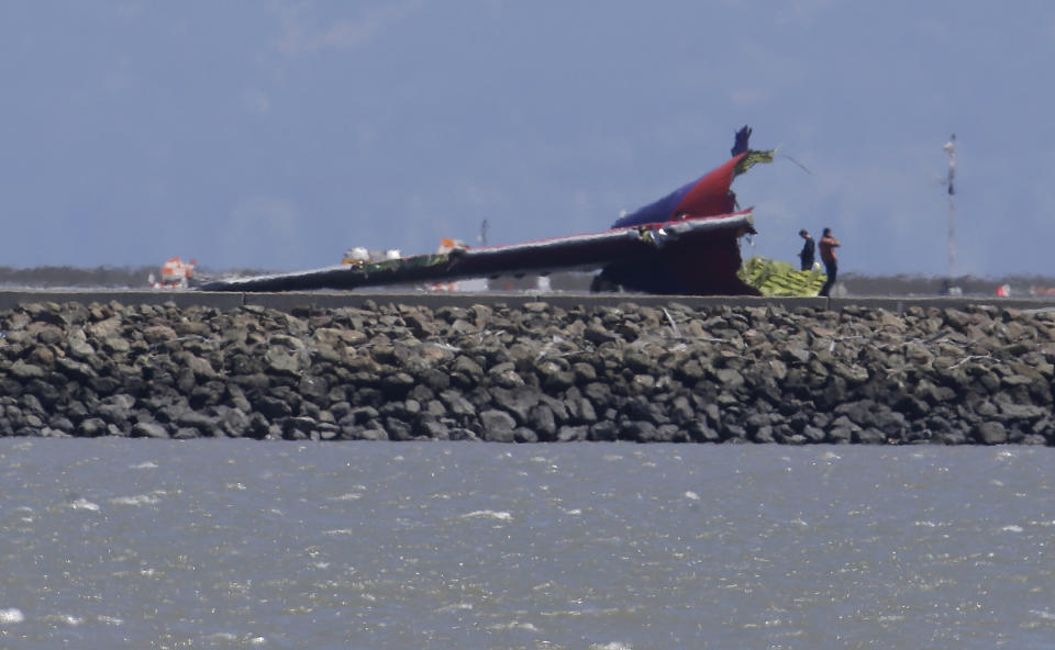 The tail of Asiana Flight 214, which crashed on Saturday, July 6, 2013, is seen on a tarmac at San Francisco International Airport in San Francisco, Wednesday, July 10, 2013. Investigators are struggling to piece together what went wrong in an accident that left two of the 307 aboard dead and close to 20 seriously injured. (AP Photo/Jeff Chiu)