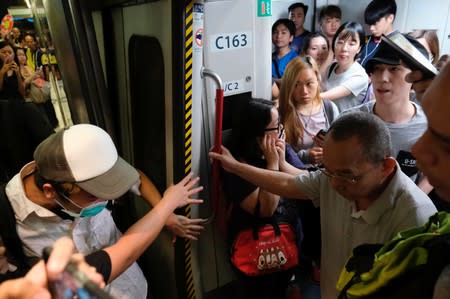 Anti-extradition bill demonstrators block the Mass Transit Railway (MTR) train in Hong Kong