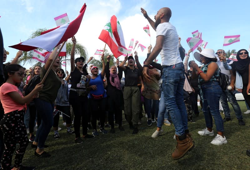 Demonstrators chant and carry national flags during an anti-government protest in the southern city of Tyre