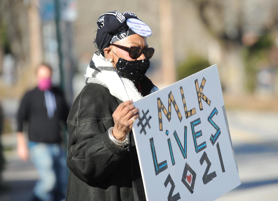 Sallie Tighe, of Truro, held a sign in Wellfleet last year to attract donations of nonperishable food for the Wellfleet Food Pantry. That collection will again be part of Monday's observance of the holiday for the Rev. Dr. Martin Luther King Jr. by the ArtPeaceMakers collective.