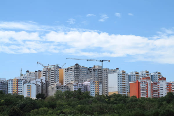 Residential modern apartment house, green forest and blue sky