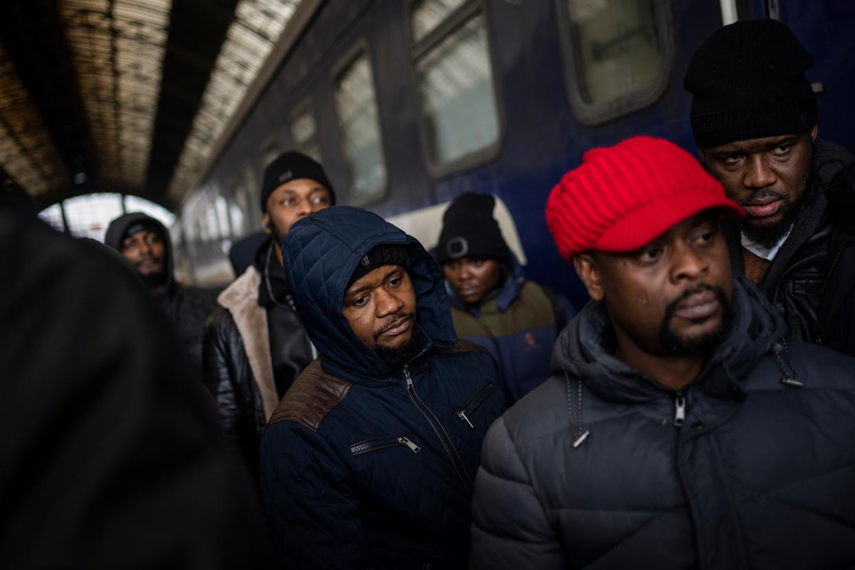 African residents in Ukraine wait at the platform inside Lviv railway station on Sunday, Feb. 27, 2022, in Lviv, west Ukraine. Hundreds of thousands of Ukrainians seek refuge in neighboring countries, cradling children in one arm and clutching belongings in the other.