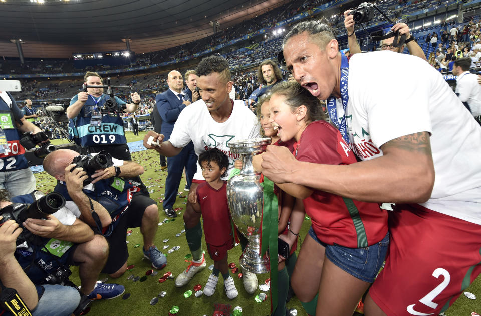 FILE - In this Sunday, July 10, 2016 file photo, Portugal's Bruno Alves, right, and Nani pose for photos with trophy at the end of the Euro 2016 final soccer match between Portugal and France at the Stade de France in Saint-Denis, north of Paris. When it comes time for Brazilians to choose who to watch on the soccer field this month — Neymar or Kylian Mbappé, Lionel Messi or Cristiano Ronaldo — the response might be surprising. Because of an unusual set of circumstances, it will be the European Championship that reaches more viewers in Brazil than the Copa America — even though Brazil is expected to host South American the tournament under a completely different set of unusual circumstances.(AP Photo/Martin Meissner, File)