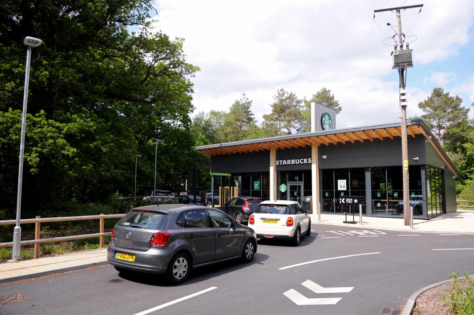 FLEET, ENGLAND - MAY 15: A general view as customers queue in their cars outside a Starbucks drive-through on the day after it's re-opening on May 15, 2020 in Fleet, England. The prime minister announced the general contours of a phased exit from the current lockdown, adopted nearly two months ago in an effort curb the spread of Covid-19. (Photo by Alex Burstow/Getty Images)