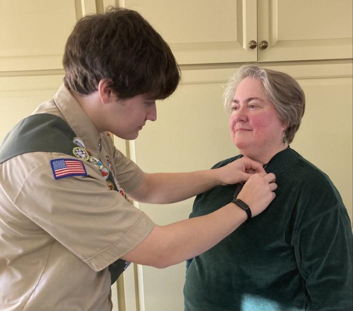 Eagle Scout John Bennett pins his Mother’s Recognition pin on his mother, Christine Bennett.