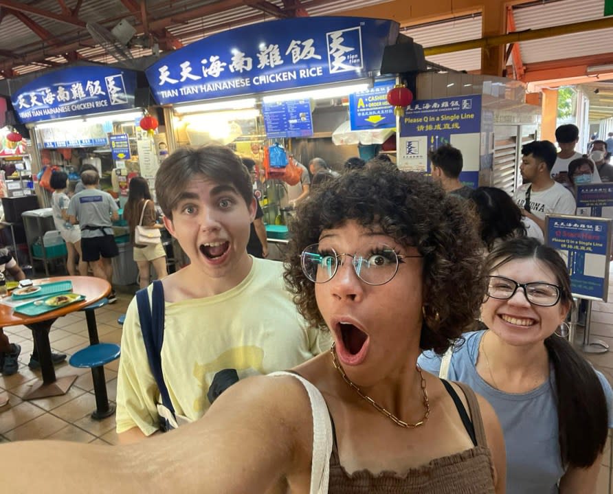 Ethan Forsberg, Addison Cox and Jacinda Garcia in front of the Hainan Chicken Rice stall during a scavenger hunt in Singapore (Monmouth College)