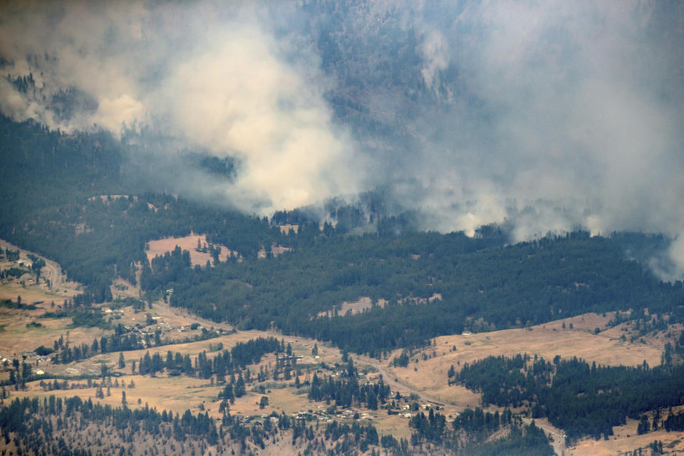 FILE - In this Thursday, July 1, 2021 file photo, a wildfire burns in the mountains north of Lytton, British Columbia, Canada, during record high temperatures. According to a study released on Wednesday, July 7, 2021, the deadly heat wave that roasted the Pacific Northwest and western Canada “was virtually impossible without human-caused climate change” which also added a few extra degrees to the record-smashing warmth. (Darryl Dyck/The Canadian Press via AP, File)