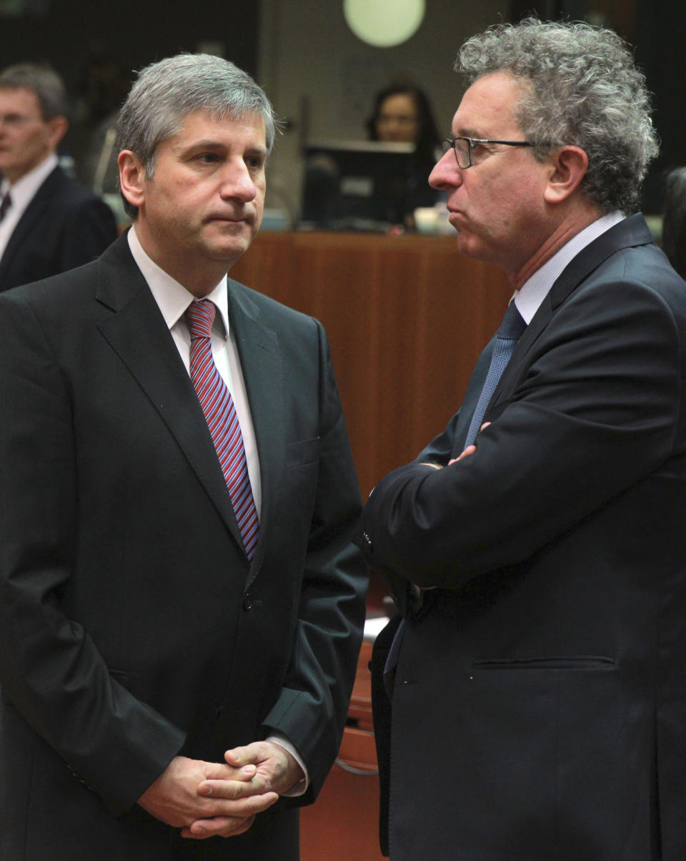 Austrian Finance Minister Michael Spindelegger, left, talks with his Luxembourg's countepart Pierre Gramegna at the start of an EU finance ministers meeting at the European Council building in Brussels, Tuesday, March 11, 2014. The Council prepares the presidency's mandate to finalize negotiations with the European Parliament on the proposal for a single resolution mechanism for banks. (AP Photo/Yves Logghe)