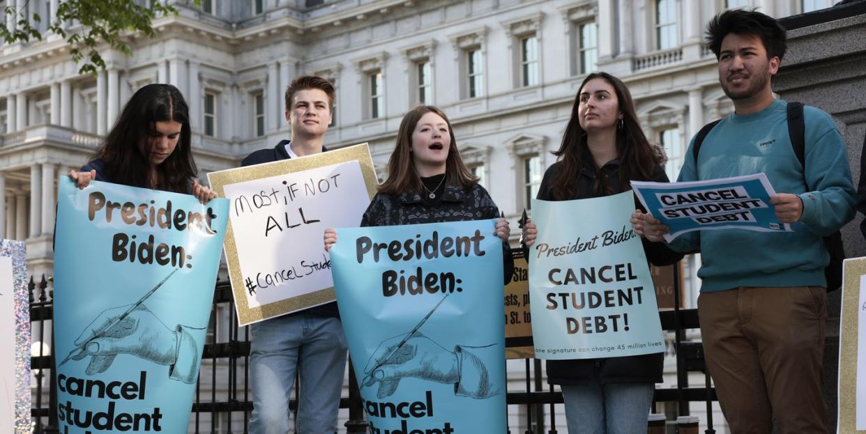 washington, dc   april 27 activists hold signs as they attend a student loan forgiveness rally on pennsylvania avenue and 17th street near the white house on april 27, 2022 in washington, dc student loan activists including college students held the rally to celebrate us president joe bidens extension of the pause on student loans and also urge him to sign an executive order that would fully cancel all student debt photo by anna moneymakergetty images