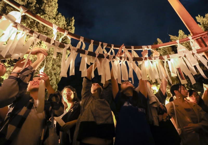 香港人民走上街頭表達「反送中」立場引發全球關注，台灣大學學生14日晚間在台大傅鐘前發起「台大撐香港－台大人反送中之夜」活動，大批學生到場聲援，並在傅鐘綁上白絲帶為香港加油。中央社記者裴禛攝  108年6月14日